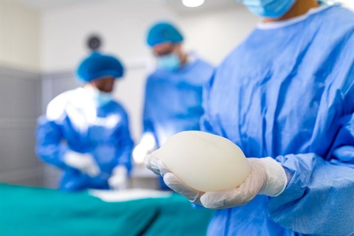 Archivo - Cirujano sujetando implante mamario de silicona en quirófano. Primer plano de un médico preparándose para la cirugía de aumento de pecho. Concepto de sanidad y medicina. Especialista en cirugía plástica.