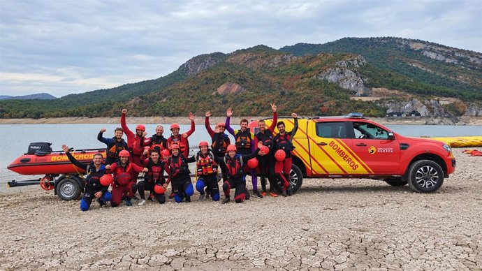 Equipo de rescate de bomberos al lado de un embalse.
