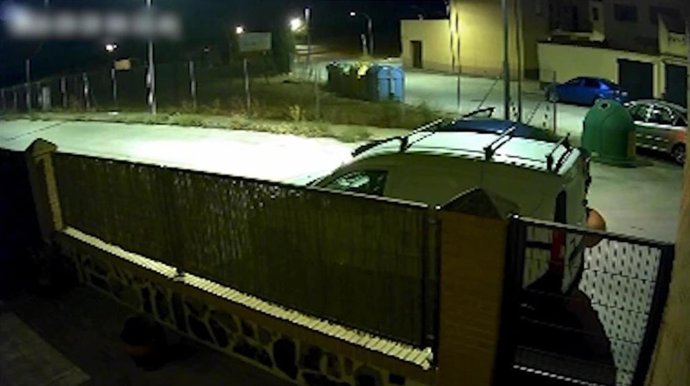 Imagen captada por una cámara de videovigilancia de un asalto a un vehículo estacionado.