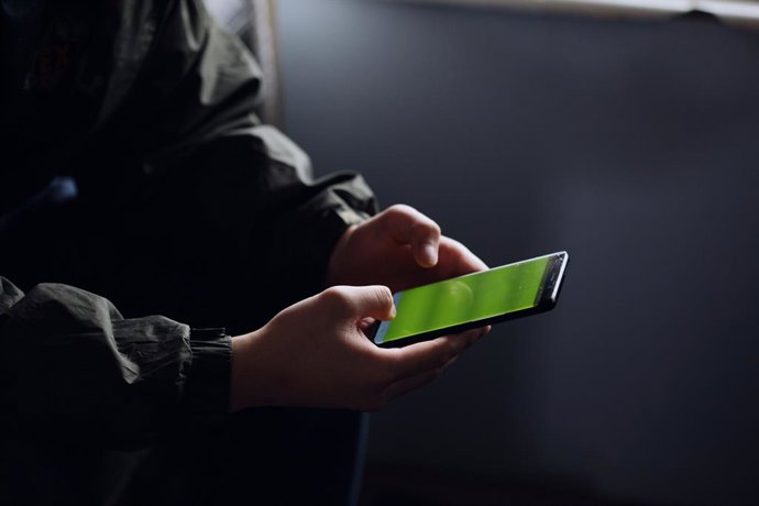 Imagem de uma pessoa segurando um celular nas mãos