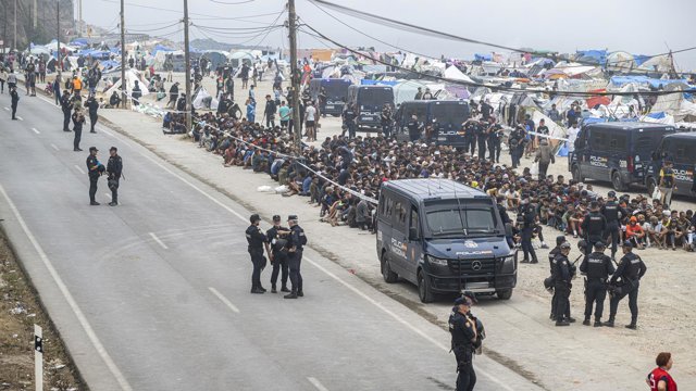 Agentes de la Policía Nacional intervienen durante el proceso de desalojo del embolsamiento de migrantes en la playa de El Trampolín, a 4 de octubre de 2026, en Ceuta (España).