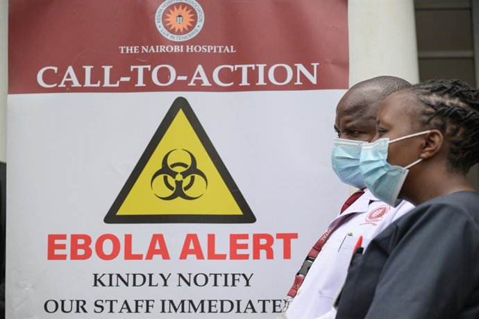 NAIROBI, Oct. 7, 2026  -- Medical workers walk past an Ebola alert poster at Nairobi Hospital in Nairobi, Kenya, Oct. 7, 2026. Kenya on Tuesday confirmed its first imported case of Bundibugyo Ebola virus disease, one day after a man died in a Nairobi hosp