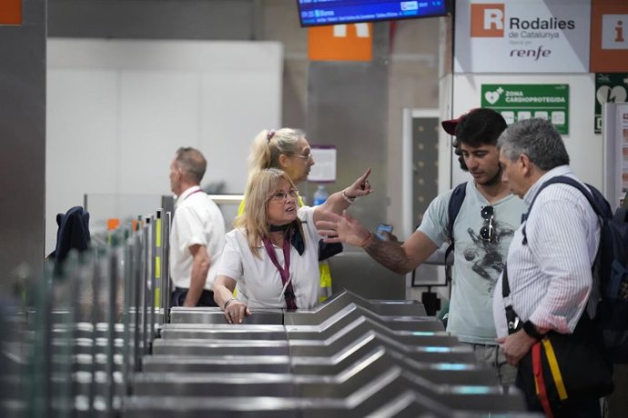 Trabajadores informan a los pasajeros de las incidencias por la lluvia en la estación de Sants