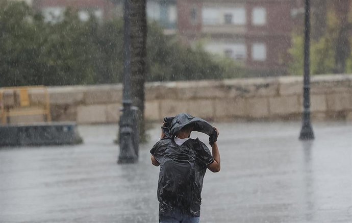 Archivo - Una persona camina bajo la lluvia. ARCHIVO. 