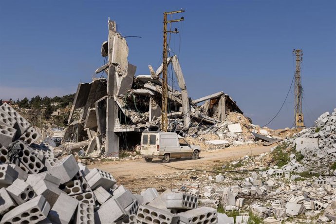 Archivo - Un vehículo pasa junto a un edificio destruido por soldados israelíes el 28 de febrero de 2025 en Kfarkela, Líbano