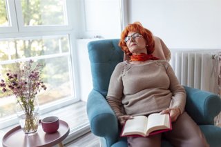 Archivo - Mujer durmiendo la siesta en un sofá mientras leía un libro.