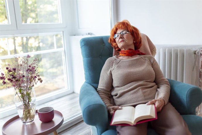 Archivo - Mujer durmiendo la siesta en un sofá mientras leía un libro.