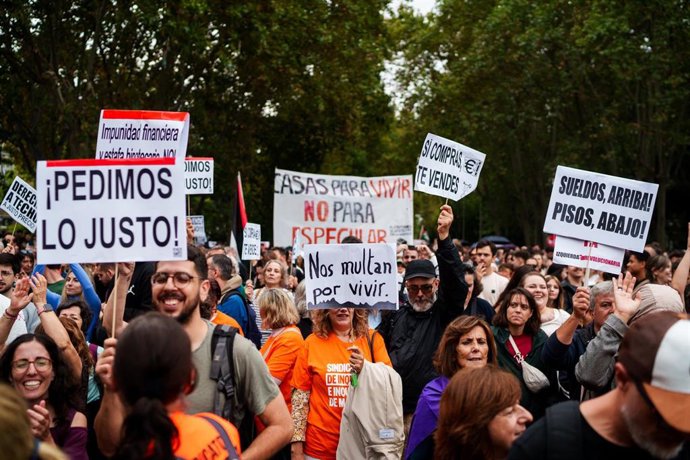 Varias personas sostienen pancartas con lemas 'Pedimos lo justo', 'Nos multan por vivir', 'Casas para vivir no para especular' durante la manifestación para exigir una reducción del precio de los alquileres de la vivienda, a 3 de octubre de 2026, en Madri