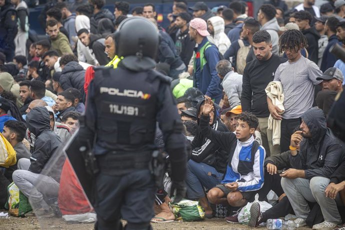 Agentes de la Policía Nacional intervienen durante el proceso de desalojo del embolsamiento de migrantes en la playa de El Trampolín, a 4 de octubre de 2026, en Ceuta (España).
