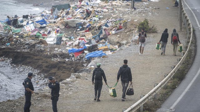 Agentes de la Policía Nacional intervienen durante el proceso de desalojo del embolsamiento de migrantes en la playa de El Trampolín, a 5 de octubre de 2026, en Ceuta (España).