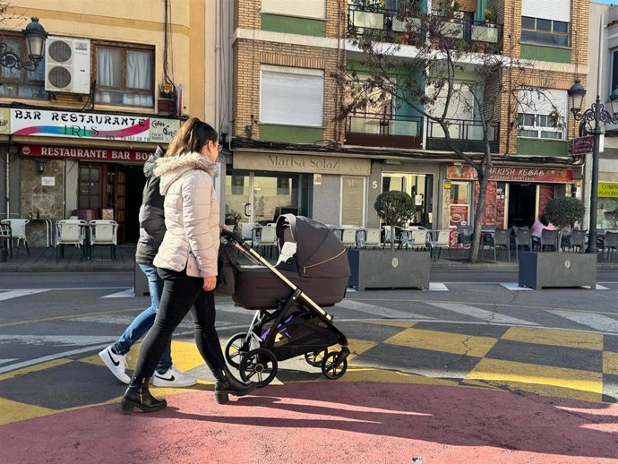 Archivo - Personas paseando con un carro de bebé