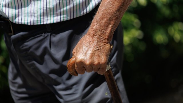 Archivo - Un hombre mayor pasea apoyándose en un bastón.