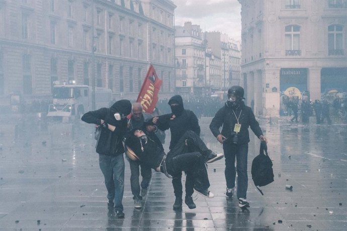 17 October 2026, France, Paris: Protesters carry an injured man through the rain at Place de la Republique in Paris during nationwide demonstrations involving the Yellow Vests (Gilets Jaunes) movement, high school students and youth-led groups, amid clash