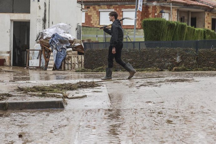 Varias personas quitan el barro de las calles mientras se acumula el mobiliario que han tenido que sacar debido a las inundaciones por las fuertes lluvias, a 19 de octubre de 2026, en Els Poblets