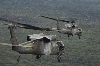 Archivo - Dos helicópteros UH-60 Black Hawk del Ejército de Colombia sobrevuelan una zona selvática de Colombia