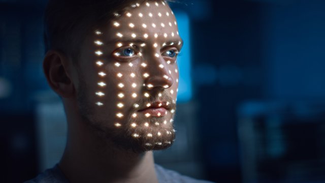 Archivo - El hombre joven caucásico guapo es identificado por el proceso de escaneo de reconocimiento facial biométrico. Escaneando con láser para IA