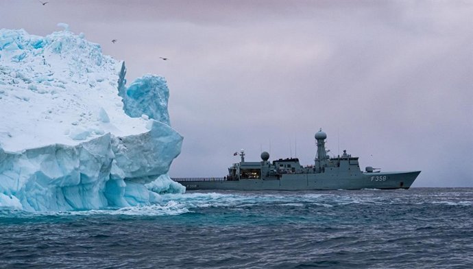 La fragata HDMS Triton de la Marina Real danesa pasa junto a un iceberg en aguas de Groenlandia.