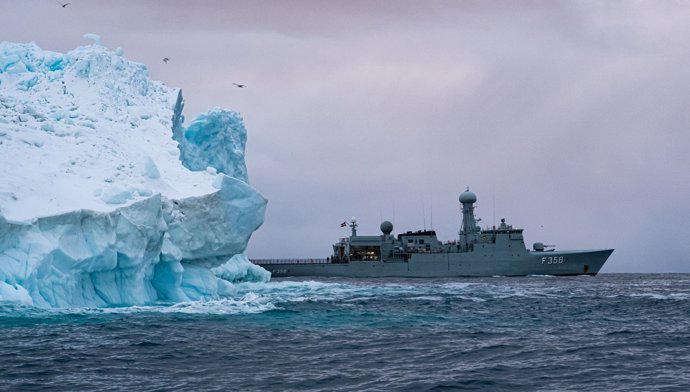 A fragata HDMS Triton, da Marinha Real Dinamarquesa, passa ao lado de um iceberg nas águas da Groenlândia.