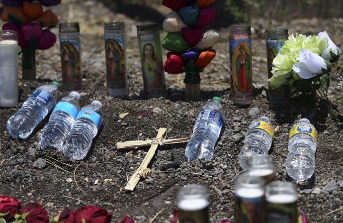 Archivo - June 29, 2022, San Antonio, TX, USA: Days after 51 migrants were found deceased inside a tractor trailer on the city's Southwest side, a memorial has grown for people to mourn the loss of life. Flowers, candles and crosses have been placed near 