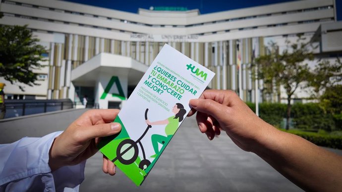 Sanitario dando un tríptico con información médica a una mujer como foto de recurso