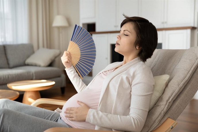 Archivo - Mujer embarazada abanicándose por el calor.