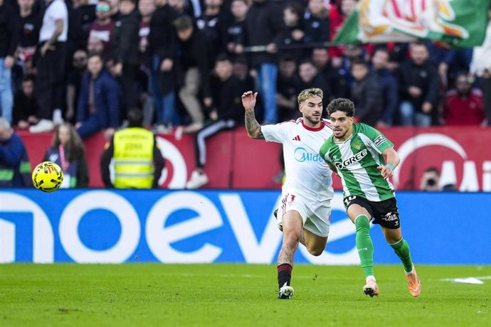 Archivo - Los jugadores Peque (izquierda) y Abde (derecha) disputando el Gran Derbi Sevilla FC - Real Betis en el estadio Ramón Sánchez Pizjuán.