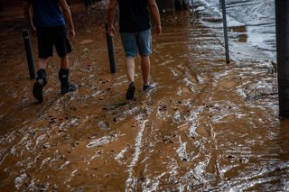 Una persona camina entre el barro de las calles a causa de las lluvias torrenciales de la pasada noche, a 4 de octubre de 2026, en Sant Adrià de Besòs, Barcelona, Catalunya (España). Protecció Civil de la Generalitat ha enviado un Es-Alert a la población 