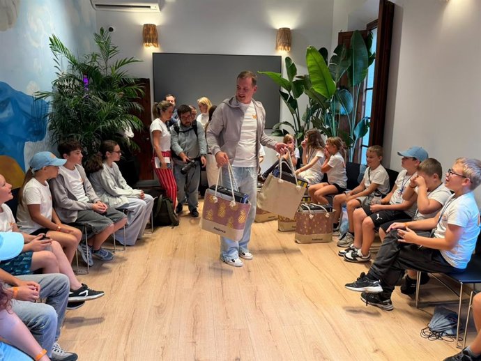El cónsul honorario de Ucrania en Baleares, Volodymyr Nosov, regala una bolsa de Mallorca que contiene una PlayStation 5 a los niños participantes del primer W Camp.