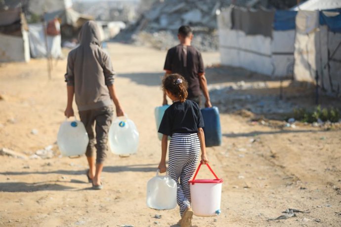 18 de outubro de 2026, Nuseirat, Faixa de Gaza, Território Palestino: Palestinos deslocados, incluindo crianças, se reúnem para buscar água no campo de refugiados de Nuseirat, na região central da Faixa de Gaza, em 18 de outubro de 2026. A região continua