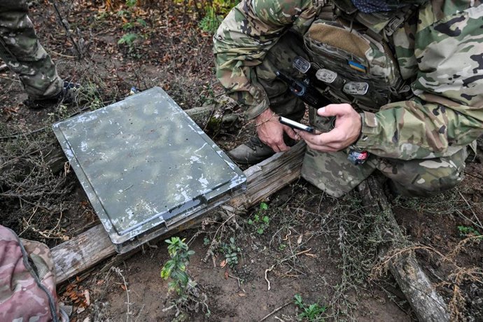 Archivo - Un soldado ucraniano utiliza un smartphone para comprobar la calidad de la señal mientras instala una red de comunicación por satélite Starlink en una posición de combate en la región de Donetsk, Ucrania
