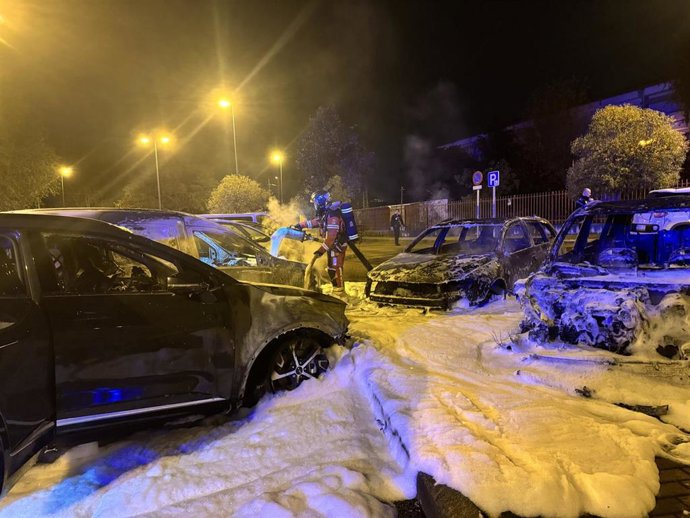 Bomberos de la Comunidad de Madrid trabajando en las labores de extinción de las llamas en un aparcamiento en superficie en Leganés, Madrid.