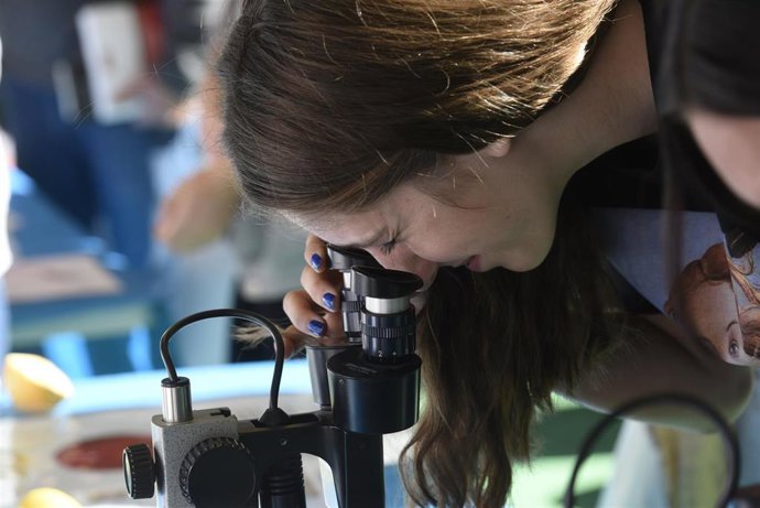 Archivo - Una joven participa en una actividad científica