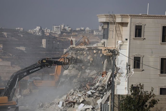 23 de outubro de 2026, Hebron, Palestina, Estado de: HEBRON, PALESTINA, 23 DE OUTUBRO DE 2026: Forças israelenses demolem um prédio residencial palestino na área de Farsh al-Hawa, em Hebron, na Cisjordânia ocupada. A demolição ocorre após um ataque a tiro