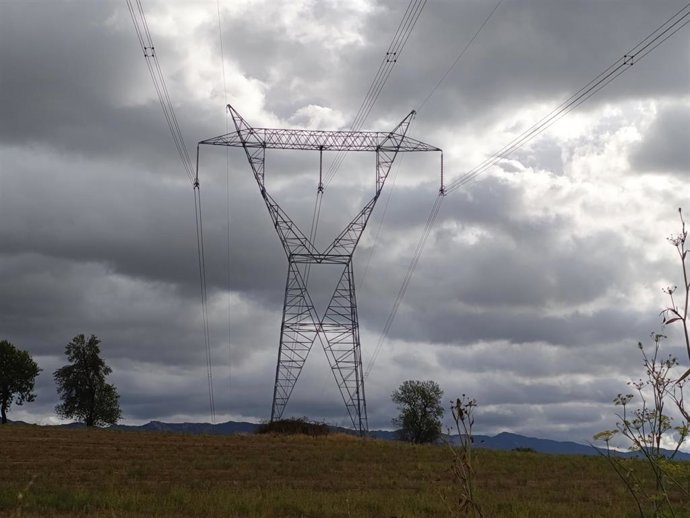 Torres de electricidad y tensión con cielos nublados