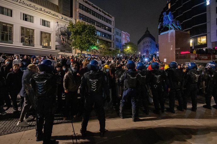 25 de outubro de 2026, Porto, Portugal: Um cordão policial avança pela Praça D. João I durante a operação noturna para desocupar o acampamento de protesto pela moradia. Os manifestantes permaneceram no acampamento de protesto pela moradia na Praça D. João