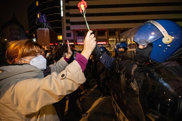 October 25, 2026, Porto, Portugal: A protester holds a red carnation in front of police officers during the overnight operation to clear the housing protest camp at PraÃa D. João I. Demonstrators remained at the housing protest camp in PraÃa D. João I, 