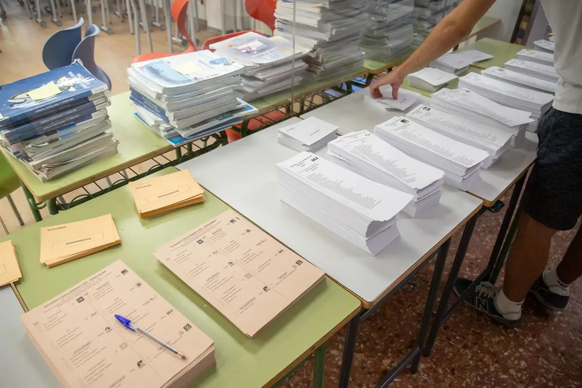 Un votante cogiendo papeletas durante las elecciones generales