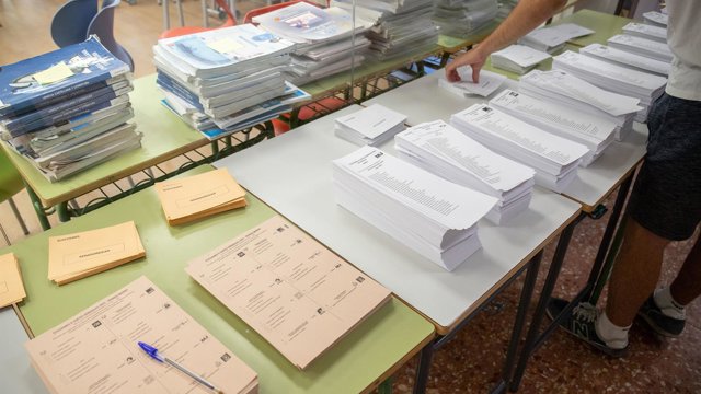 Archivo - Un votante cogiendo papeletas durante las elecciones generales