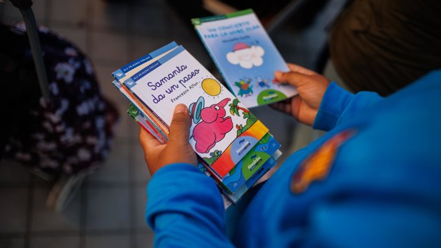 Archivo - Un niño recibe unos libros.