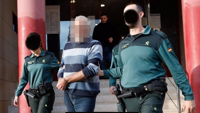 El acusado por la muerte de su pareja sentimental en la urbanización Camposol, en Mazarrón, sale de los juzgados de Totana custodiado por dos agentes de la Guardia Civil tras ser detenido