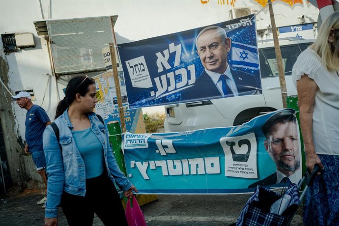 23 October 2026, Israel, Tel Aviv: A woman walks past campaign banners hanging from a fence displaying Prime Minister Benjamin Netanyahu for Likud (top) and Finance Minister Bezalel Smotrich for the Religious Zionist Party (bottom) in Tel Aviv. Israel is 