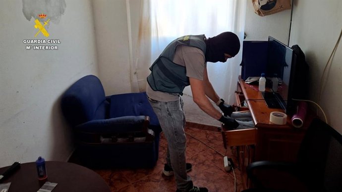 Imagen de uno de los agentes durante el registro de una vivienda usada como punto de venta de drogas.