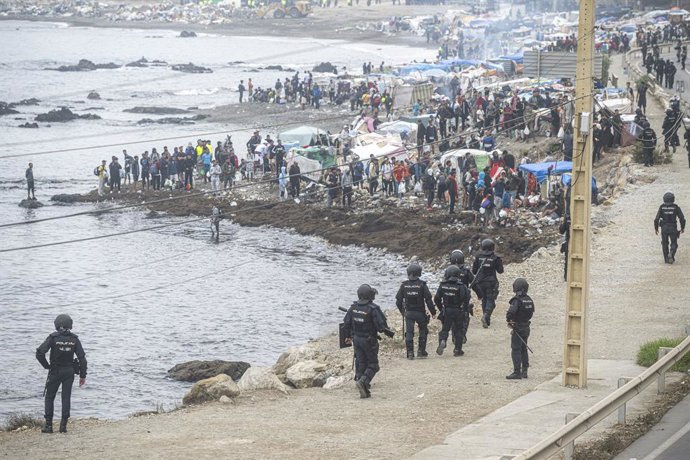 Agentes de la Policía Nacional intervienen durante el proceso de desalojo del embolsamiento de migrantes en la playa de El Trampolín, a 4 de octubre de 2026, en Ceuta (España).