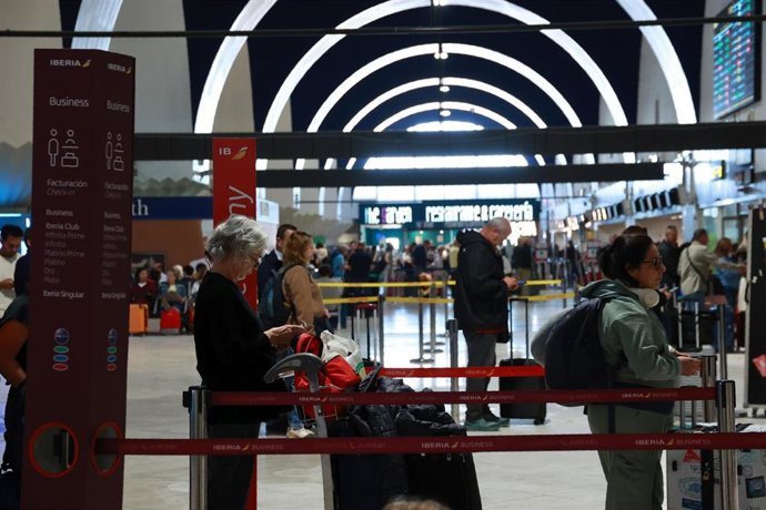 Pasajeros en el aeropuerto de Sevilla en uno de los mostradores de embarque, este jueves, el día después del accidente ferroviario de Urda