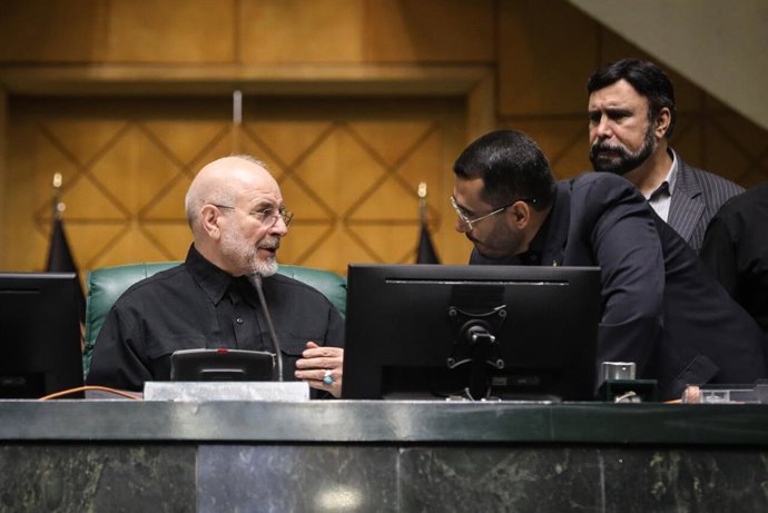 25 de outubro de 2026, Teerã, Irã: Mohammad Bagher Ghalibaf conversa com um homem inclinado sobre a mesa da presidência, enquanto outro autoridade fica em pé atrás deles na Assembleia Consultiva Islâmica, em Teerã, Irã, em 25 de outubro de 2026. O preside