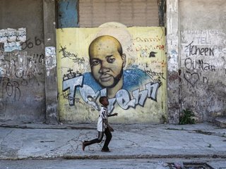 Archivo - Un niño pasea delante de un mural en Puerto Príncipe, la capital de Haití, en imagen de archivo 